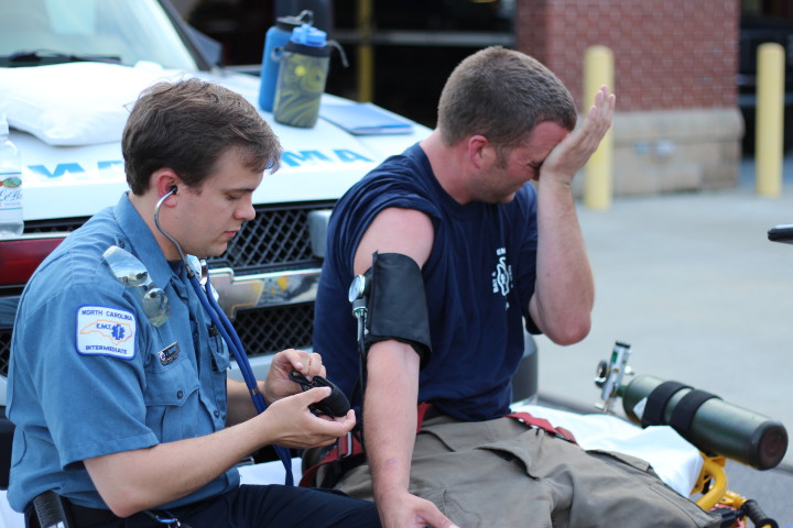 VITALS: Rescue squad members check vitals of firefighters on a training mission. (Mountain Xpress / Jesse Farthing)