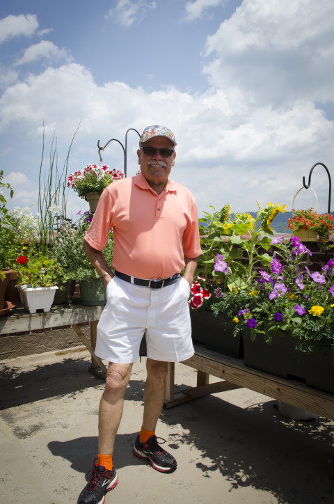 A reclaimed paradise: Edwin Gonzalez says he took over the neglected rooftop garden at Battery Park Apartments in order to create something beautiful for the building's residents. (Carrie Eidson/ Mountain Xpress)