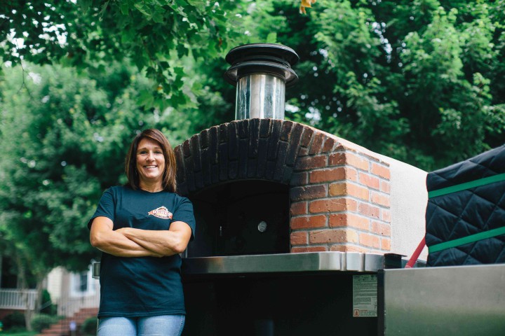 A MOVEABLE FEAST: “We wanted to be able to be outside and to chitchat and meet people. We didn't want to be enclosed,” Debbie Barry says about her business, Mama Dukes Wood Fired Oven. It centers around a custom-built, wood-burning brick oven on wheels. Photo by Tim Robison