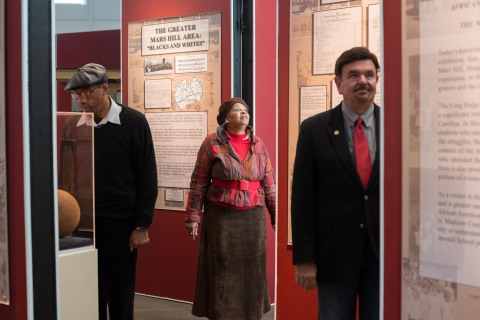 VIEWING HISTORY: The Rural Heritage Musuem's "Our Story: This Place" exhibit highights African-American education in Madison County, including the Rosenwald School (pictured: former students Fatimah Shabazz, center; Omar McClain, left; and museum director Les Reker, right). Photo by Pat Barcas
