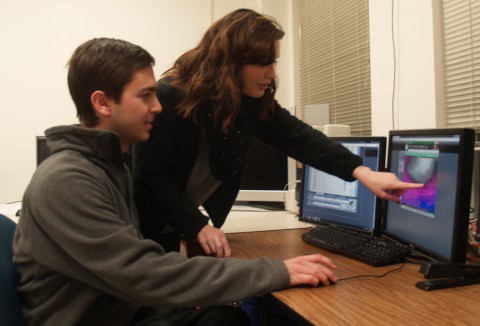 Massey Bartolini and Kelly Dobeck use computer programs to examine weather models.