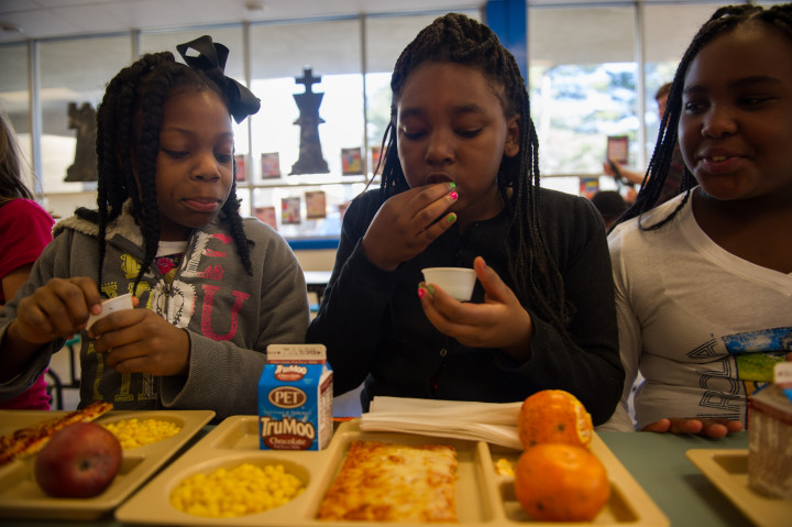 SOMETHING NEW: Hall Fletcher students, from left, Adreyona Smith, Ana'ya Harper and Zyniha Davis, try kale, cheese and apple salad.  Photo by Pat Barcas