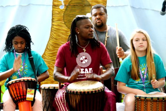 THE BEAT GOES ON: Adama Dembele, center, of local Afropop band Zansa, drums with students in a LEAF Schools & Streets  program.