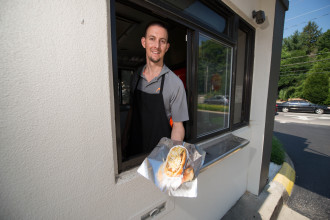 IN THE NEIGHBORHOOD: At Kevin Dolinger’s Merrimon Avenue drive-thru, Brätburger, Johnsonville bratwursts served on buns baked just down the road at Geraldine’s Bakery are a specialty. Photo by Pat Barcas