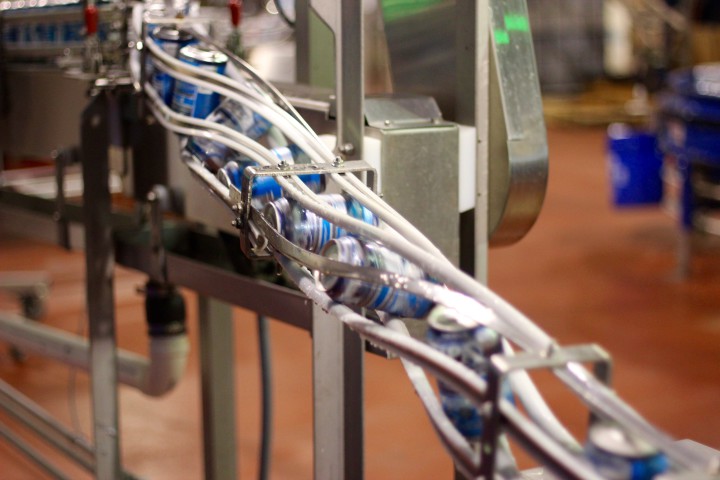 Cans of Oskar Blues IPA tumble down the line. Photo by Jesse Farthing.