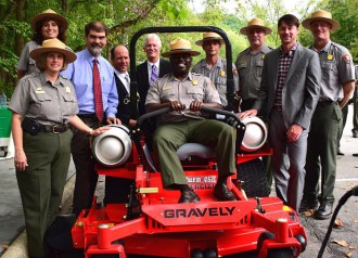 Park staff and others join Cash with one of the new propane mowers. Photo courtesy of Land of Sky.