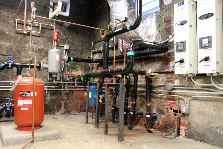 In a mechanical room below the sanctuary of Asheville’s First Congregational United Church of Christ, pumps circulate water through a closed geothermal heating and cooling system. Photo by Virginia Daffron