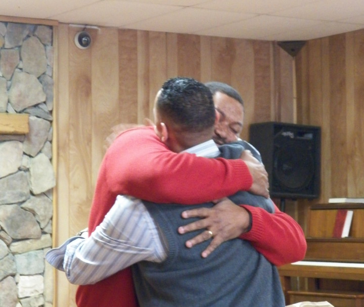 Street Smarts: Executive director Micheal Woods embraces a graduate of  Western Carolina Rescue Ministries' men's recovery program. The shelter is trying new approaches to keep people from having to return to a shelter after they transition to life in a home. Photo courtesy of Western Carolina Rescue Ministries