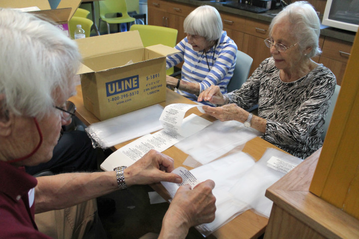 PACKING A PUNCH: Volunteers from Givens Estates label bags for MANNA's bulk repackaging program. Photo courtesy of MANNA FoodBank