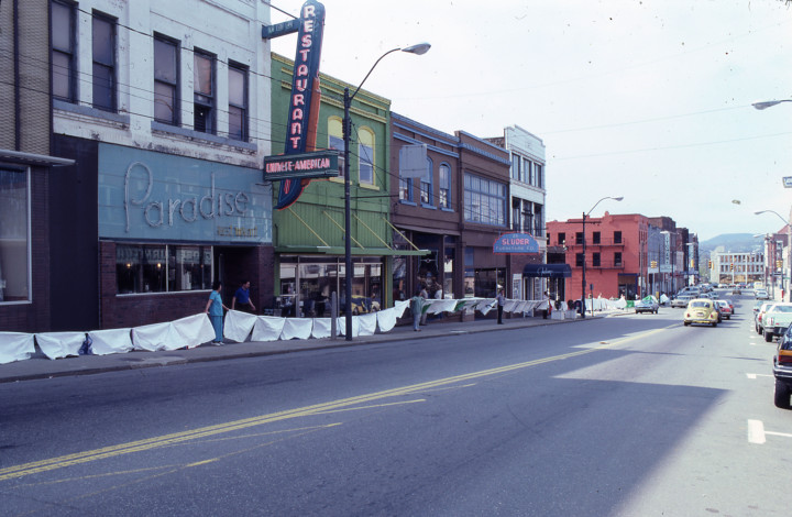 ALL WRAPPED UP:  Peggy Gardner’s project to “wrap” — in strips of cloth tied together — all of the buildings in an 11-block area that would have been demolished under the Strouse Greenberg & Co. downtown mall complex proposal. Two hundred people participated. Photo by Annie R. Martin, April 19, 1980.