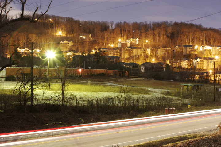 NIGHT VISONS: A nighttime photograph of the former CTS of Asheville facility with surrounding homes in the background. The building was torn down by Buncombe County in 2011. Photo special to Xpress