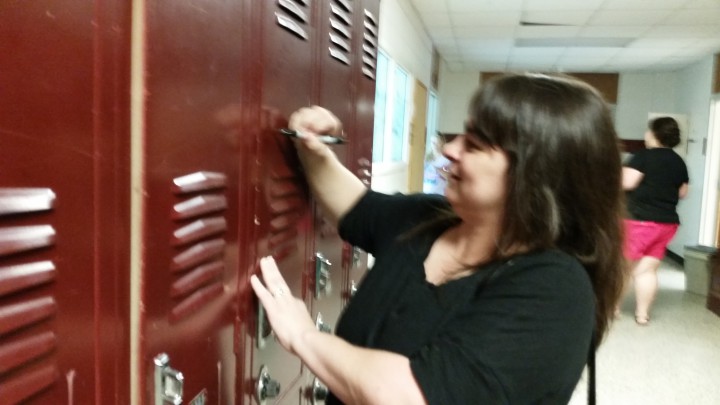 Emily Thomas, clas of 1994, writes has name on a locker at Asheville Middle School