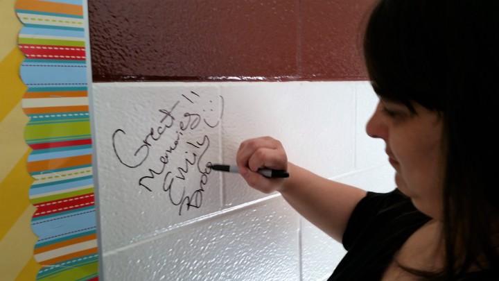 Emily Thomas signs the wall.