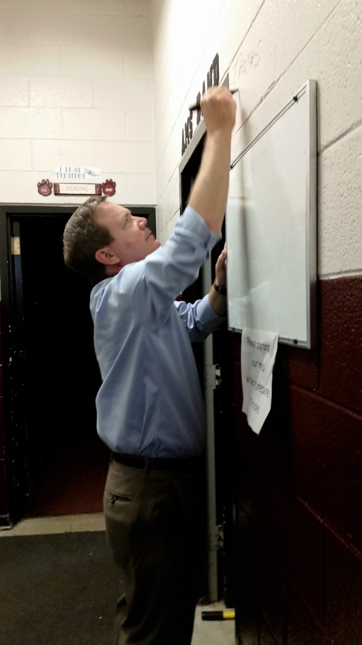Brad Blackburn writes his sons' names near the entrance of the band room at Asheville Middle School.