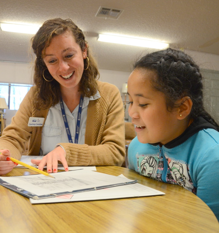 AN ACADEMIC BOOST: Children First/CIS Student Support Specialist Courtney Crenshaw tutors a student.