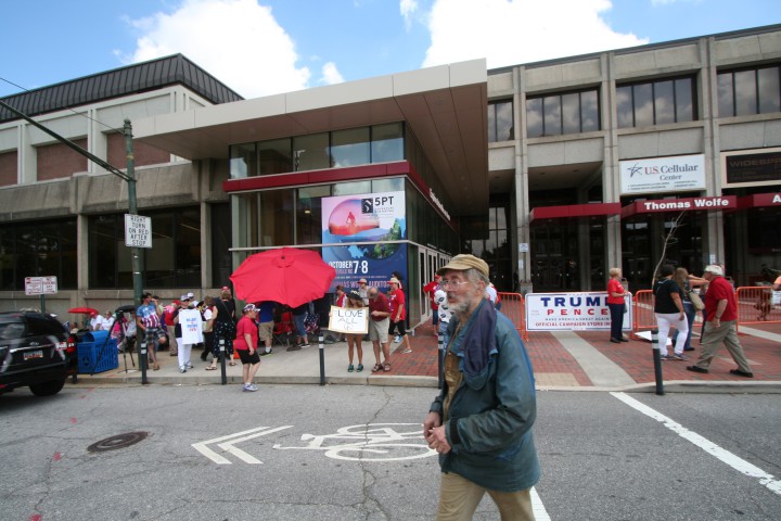 People are milling around the entrance of the US Cellular Civic Center. Some holding signs, some waiting in line, while others seem to be taking in the spectacle. Photo by Dan Hesse