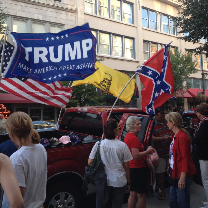 A man sells flags from his pickup truck as people leave the Trump rally. Photo by Dan Hesse