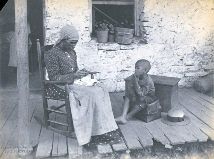 LIFE IN THE MOUNTAINS: A woman and child sit on their Western NC home, circa 1899. Photo courtesy of North Carolina Collection, Pack Memorial Public Library, Asheville, North Carolina