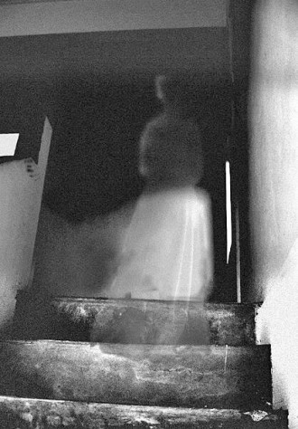 CAPTURED ON CAMERA: According to Sanders, guest and visitors to Reynolds Mansion have sent him countless photographs of orbs and ghostly apparitions captured on film inside the house. "I'm hoping to put together a coffee table book one day," Sanders laughs. This photo, which dates from the early 1970s, supposedly captured Adeline Reynolds ascending the staircase to the upper floors. Photo courtesy of Reynolds Mansion Bed and Breakfast