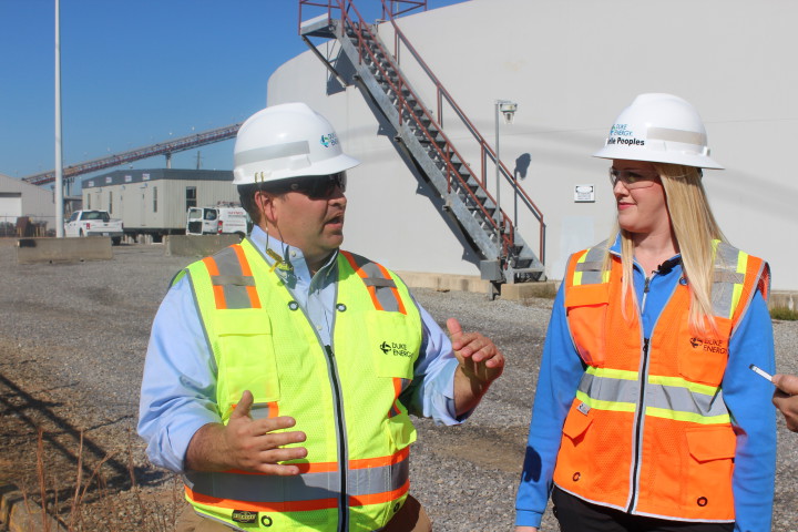 Duke Energy's Jason Walls (left) and Danielle Peoples (right) lead media representatives on a show-and-tell tour of the cleaned-up former ash basin at Duke's Lake Julian plant. Photo by Virginia Daffron