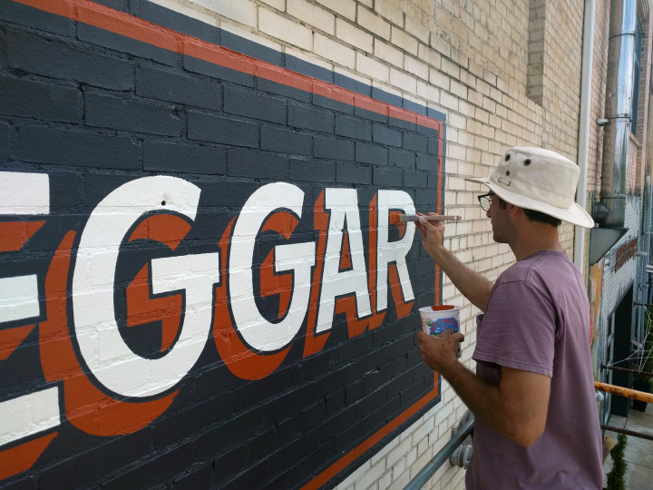 WALL DOG: Timothy Maddox continues the tradition hand-painted signs. Photo by  Aven Gully