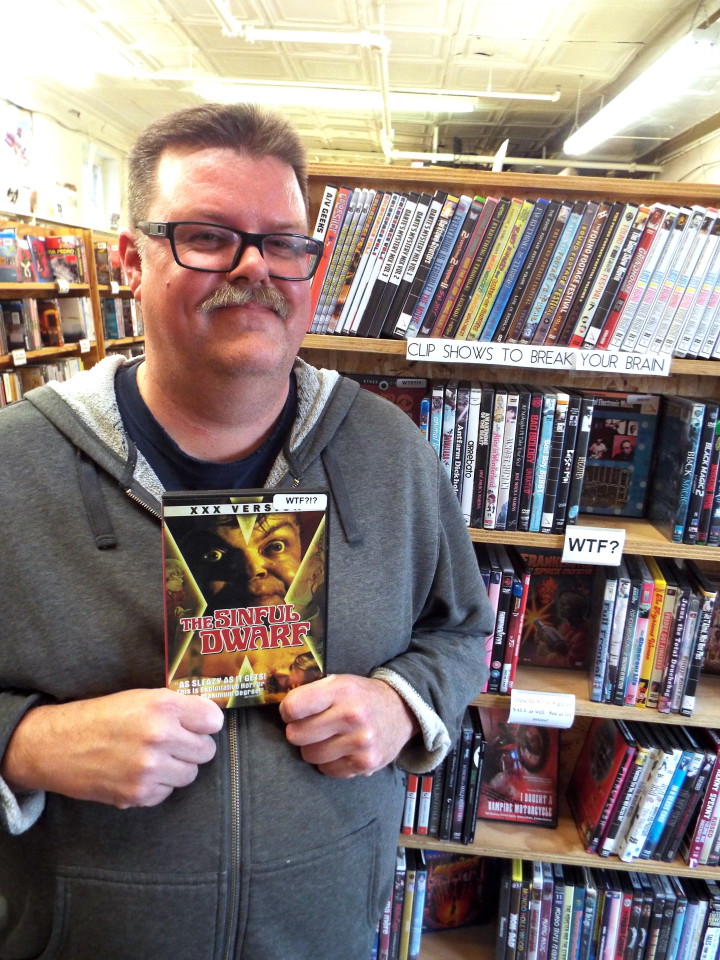 Marc McCloud is shown here holding his favorite movie from the “WTF” section, The Sinful Dwarf. Photo by Able Allen