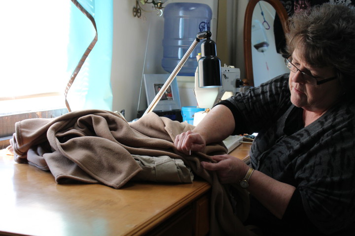 Linda carefully repairs some pants dropped off by a customer. Photo by Kari Barrows