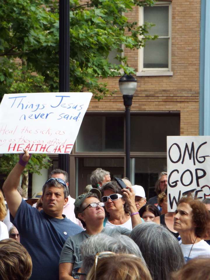 Signs lifted high, citizens concerned about the proposed healthcare law voiced their disapproval en masse in Pack Square Monday. Photo by Able Allen