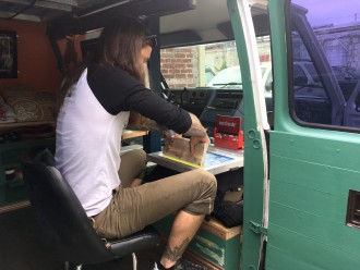 JOURNEYMAN: Making a living while living the van life requires some ingenuity. Former New Englander and current Asheville resident “Mr. Wolf” converted his van into a camper/mobile work studio and makes his custom T-shirts with a one-screen press set up inside. Other van-lifers turn a buck via “influencer marketing” on Instagram. Photo by Hokey Pokey