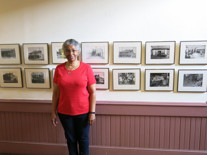 THE BLOCK: Tonia Plummer, administrative assistant at the YMI Cultural Center stands before some of the photos donated to the organization. Photo by Thomas Calder 