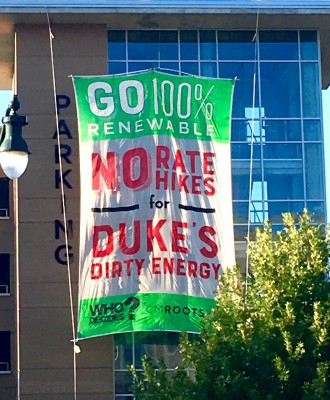 SIGNS POINT TO NO: Environmentalists dropped a giant banner on a parking garage across from the Buncombe County Courthouse before a Duke Energy Progress rate hike hearing. Photo courtesy of Richard Fireman 