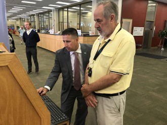 Brandon Wilson, ABCCM's assistant director for service coordination and the network director for NCServes-Western, works with a veteran using the dedicated kiosk at Pack Memorial Library. Photo courtesy of ABCCM