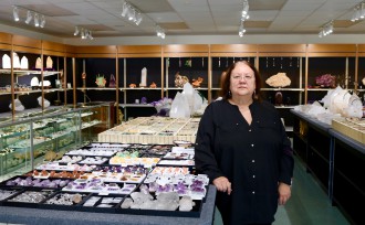 AMONG FRIENDS: Connie Olson's own rock collection served as the starting point for Points of Light Crystal and Mineral Gallery on Merrimon Avenue, and she says she feels happy when surrounded by stones. Photo by Carolyn Morrisroe