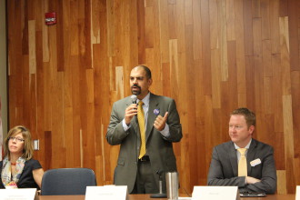 Vijay Kapoor of South Asheville (standing) addresses CIBO. Left, Mayor Esther Manheimer; Rich Lee (right). Photo by Virginia Daffron