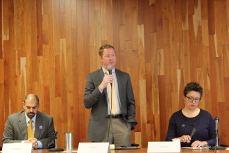 City Council candidate Rich Lee (standing), with candidates Vijay Kapoor (left) and Kim Roney (right). Photo by Virginia Daffron