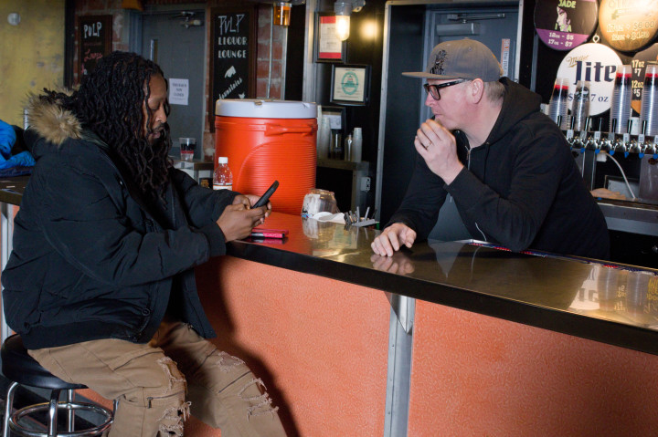 BUSINESSMEN: Local music promoter Duke “Party Man” Finley, left, and Justin Ferraby, operations manager at The Orange Peel, chat at the venue’s bar. Ferraby says he welcomes emails and calls from local hip-hop artists and is willing to give them a chance. Photo by Cindy Kunst
