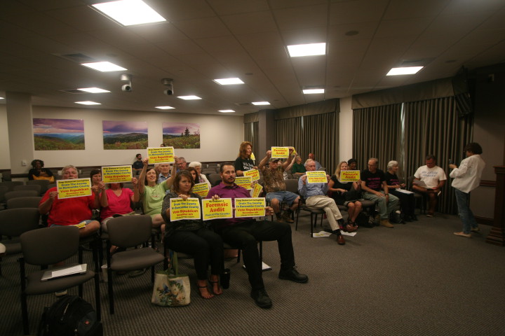 NOT PLEASED: A group of citizens showed up to the Buncombe County Board of Commissioners meeting on Aug. 21 brandishing signs calling for a forensic audit and for a Republican takeover of the board. Photo by David Floyd