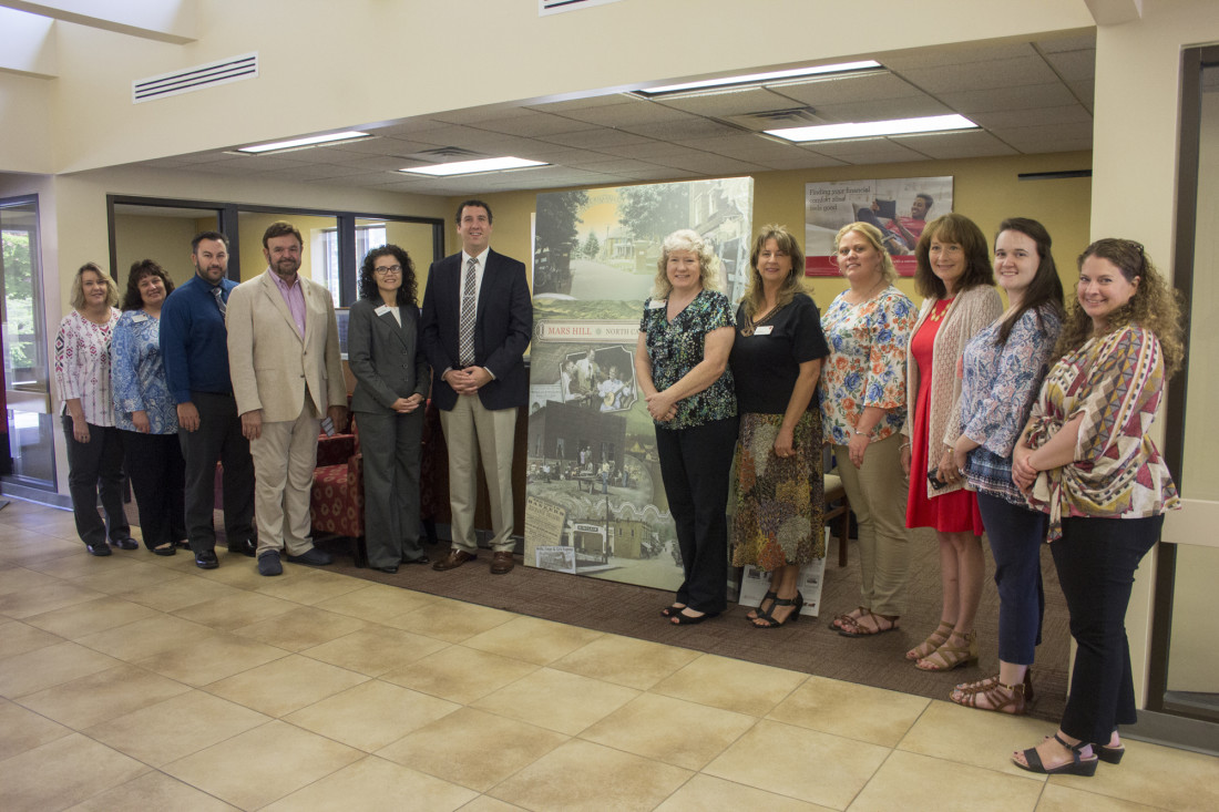 Wells Fargo and Mars Hill University employees pose with the mural the bank donated to the university.