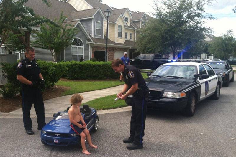 Police pulling over child in toy car