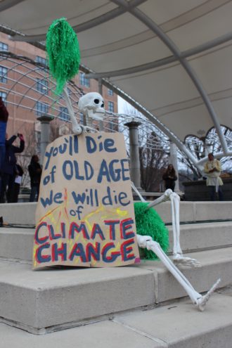 Skeleton with sign at Asheville Climate Strike