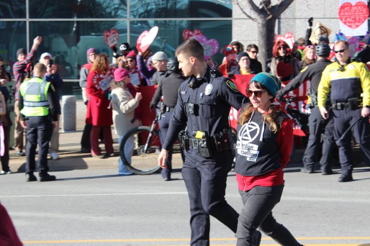Extinction Rebellion protester being escorted by Asheville Police Department