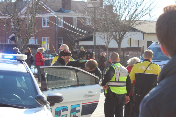 Extinction Rebellion WNC protester being put in an APD squad car