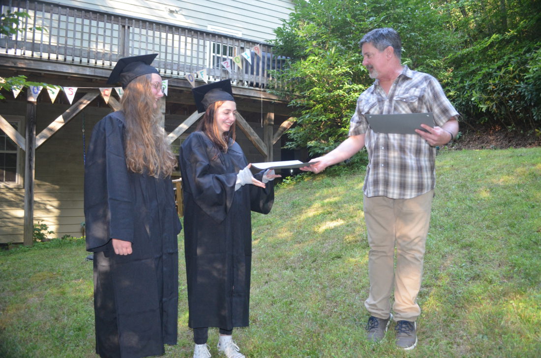 Claire Bowling, left, and Amelia Darnell receive their high school diplomas from Parkview Academy Principal Chuck Bowling