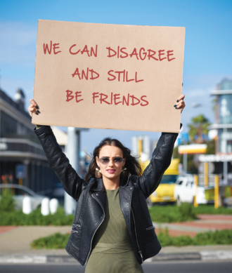 Woman holding sign saying "We can disagree and still be friends."